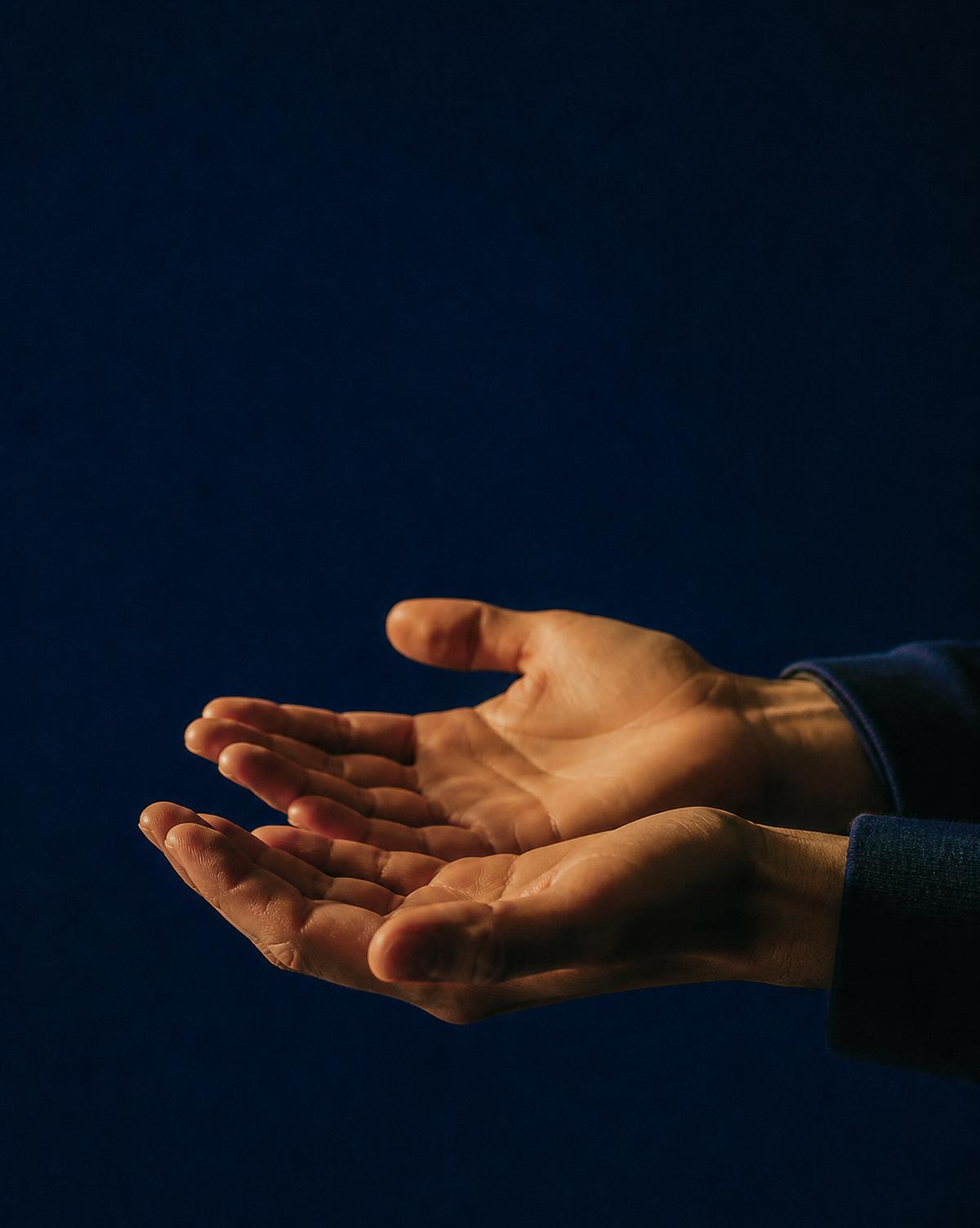 Expressive hands resting quietly, photographed in warm low light